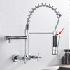 A wall-mounted kitchen faucet with a pull-down sprayer is shown against a textured wall. Podgląd zdjęcia produktu