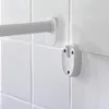 A close-up shot of a white shower curtain rod and its mounting brackets attached to a white tiled wall. Podgląd zdjęcia produktu