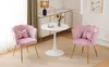 Two pink velvet chairs with gold legs are placed around a small white table in a room. Náhľad obrázku produktu