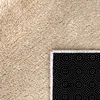 A close-up view of a beige rug with a black backing with white dots. Produktbild-Vorschau