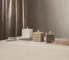 Three bubble cube candles are arranged on a wooden table in front of a textured curtain. Podgląd zdjęcia produktu