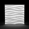 A white 3D wall panel with a wave-like texture is displayed against a black background with a subtle reflection on a gray surface. Podgląd zdjęcia produktu