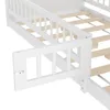 Close-up view of a white wooden bed frame with a safety rail and a small red and silver latch. Produktbild-Vorschau