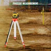 A construction site with a laser level on a tripod in the foreground and a measuring rod in the background. Podgląd zdjęcia produktu