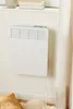 A white electric heater mounted on a light-colored wall. Podgląd zdjęcia produktu