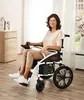 A woman is sitting in a foldable electric wheelchair in a room. Náhľad obrázku produktu