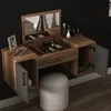 A vanity table with a mirror and storage compartments, along with a stool, against a black wall. Podgląd zdjęcia produktu