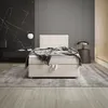 A modern bedroom with a boxspring bed, marble wall, and striped wall. Voir les images du produit