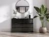 A modern dresser with a round mirror above it, next to a large potted plant. Voir les images du produit
