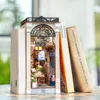 A miniature book nook designed to look like a shop, placed between two books. Podgląd zdjęcia produktu