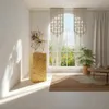 A bright, airy room with a large arched window overlooking a garden. The product, a wooden pedestal, is placed in the foreground, showcasing a decorative sculpture. Voir les images du produit