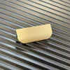 A close-up of a gold-colored handle on a black ribbed surface. Náhled obrázku produktu