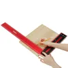 Hands using a red woodworking square to mark a wooden board with a pencil. Podgląd zdjęcia produktu