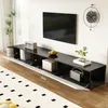 A modern black TV stand with open compartments and doors, featuring a television mounted on the wall above it. Decorative items like a plant, books, a bowl of fruit, and a radio are placed on the stand. A clock is visible on the wall. Anteprima dell’immagine prodotto