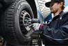 A mechanic is using a Bosch impact wrench to remove a lug nut from a car wheel. Voir les images du produit