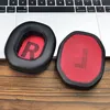 Two ear pads for headphones are placed on a wooden surface in front of a laptop keyboard. Podgląd zdjęcia produktu