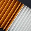 Close-up of a pleated filter with alternating orange and white sections, separated by a black frame at the top. Voir les images du produit