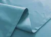 A close-up view of a teal-colored fabric, likely a curtain or drapery, showing the texture and stitching. Produktbild-Vorschau