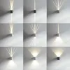 A collage of nine images showing different wall lights mounted on a textured wall, each emitting light patterns. Voir les images du produit