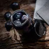 A close-up shot of plums in a glass jar on a wooden surface. Podgląd zdjęcia produktu