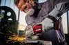 A man in protective gear uses an angle grinder to cut metal, creating sparks. Produktbild-Vorschau