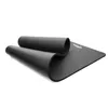 A black yoga mat is partially unrolled on a white background. Podgląd zdjęcia produktu