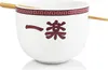 A white ramen bowl with Japanese characters and a red decorative border, with chopsticks resting on top. Podgląd zdjęcia produktu