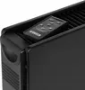 A close-up view of a black heater with a remote control resting on top. Podgląd zdjęcia produktu