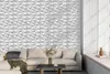 A modern living room with a textured white wall paneling and a sofa. Podgląd zdjęcia produktu