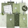 A collection of green paper advent bags with various Christmas-themed patterns, clipped together and some with numbered stickers. Anteprima dell’immagine prodotto