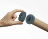A hand is holding a gray ring-shaped object above a wooden rolling pin with a gray cap on the end. Produktbild-Vorschau