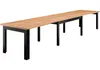 A long, extendable wooden dining table with black metal legs, shown against a white background. Produktbild-Vorschau