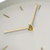 A close-up view of a clock face with gold hands and silver hour markers. Voir les images du produit