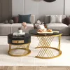 Two round coffee tables with marble tops and gold metal bases are placed in a living room setting. Produktbild-Vorschau