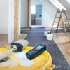 A laser distance measurer and a paintbrush are placed on a yellow bucket in a room undergoing renovation. Voir les images du produit