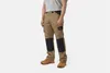 A man wearing work pants and boots, standing against a white background. Produktbild-Vorschau