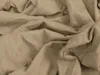 A close-up, crumpled view of beige jersey fabric. Produktbild-Vorschau