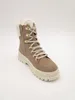 A single beige boot with white fur trim and gold eyelets is shown against a white background. Voir les images du produit