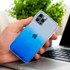 A hand holding an iPhone 12 Pro Max with a blue gradient case, resting on a laptop keyboard, with a green plant in the background. Produktbild-Vorschau