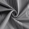 A close-up view of a gray fabric with a white wavy line pattern, swirled in the center. Produktbild-Vorschau