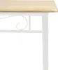 A close-up view of the corner of a table with a light brown wood grain surface and a white metal frame. Voir les images du produit