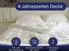 A white duvet is laid out on a bed with pillows. Produktbild-Vorschau