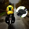 A cyclist wearing a yellow jacket and a reflective vest with LED turn signals, riding on a wet road with panniers attached to the bike. Náhľad obrázku produktu
