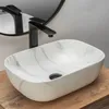 A marble-patterned countertop sink with a black faucet, set on a wooden surface. Anteprima dell’immagine prodotto