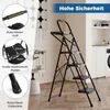 A black folding stepladder with four steps is shown in a room with a washing machine and kitchen cabinets in the background. Callouts highlight features like the non-slip handle, large textured pedals, and non-slip foot pads. Podgląd zdjęcia produktu