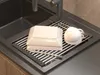 A dish drying rack with dishes and a cup on it, placed in a sink. Podgląd zdjęcia produktu