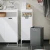 A laundry room scene with white storage cabinets and a gray laundry basket. Produktbild-Vorschau