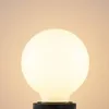 A close-up shot of a frosted white globe light bulb with a black base against a light beige background. Produktbild-Vorschau