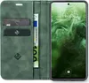 A green flip case for a smartphone, open to reveal card slots and a banknote, with the smartphone screen displaying the time and date. Produktbild-Vorschau