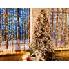 A decorated Christmas tree with presents underneath, set against a window with fairy lights. Produktbild-Vorschau